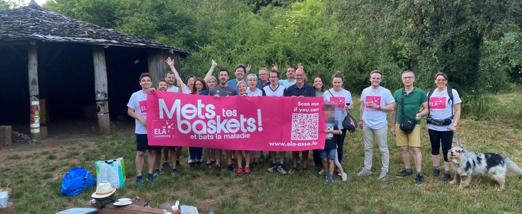 Participants à la marche solidaire de BNI Luxembourg pour ELA, derrière la bannière « Mets tes baskets ! »
