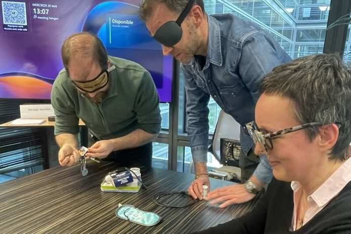 Des collaborateurs, les yeux bandés, assemblent un puzzle lors d'un atelier de mise en situation